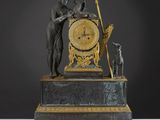 une statue représentant un homme et une femme tenant une horloge