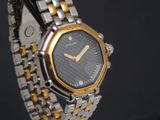une montre-bracelet en argent et en or avec un cadran noir