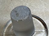 a glass of water sitting on top of a metal plate