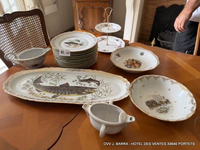 many plates and bowls on a table with a man standing in the background