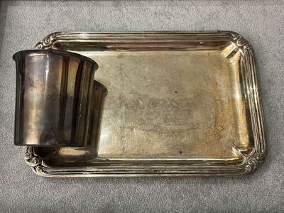 a silver tray with a silver cup on top of it