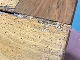 a close up of a wooden table with holes in it