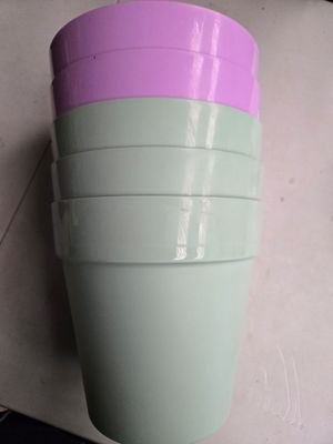 des tasses violettes et vertes empilées les unes sur les autres sur un plan de travail