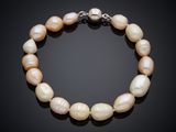a white pearl bracelet with a silver clasp on a black background