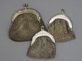 trois sacs à main anciens en maille argentée sur fond gris