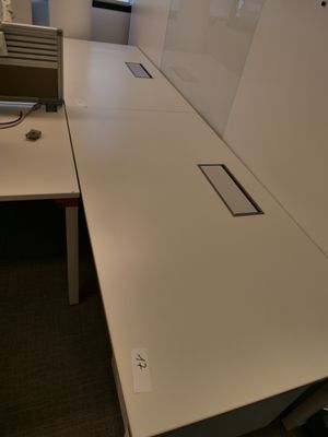un bureau blanc sur lequel se trouve un ordinateur, dans un bureau