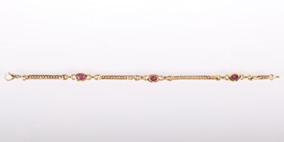 un gros plan d'un bracelet en or orné de pierres roses