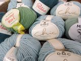 many balls of yarn sitting in a wooden box