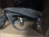 a black bag sitting inside of a box on the ground