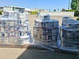 many cans of water sitting on a pallet in the parking lot