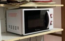 un micro-ondes posé sur une étagère dans une cuisine