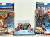 three action figures of different characters in plastic packaging on a white surface