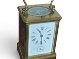 a small brass clock with a blue face on a white background