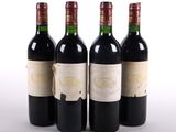 trois bouteilles de vin rouge sont alignées sur une surface blanche