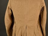 a brown jacket on a mannequin stand against a black background