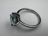 a close up of a ring with a blue topaz stone