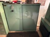 une armoire verte dans la cuisine, dont la porte est ouverte