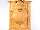 une armoire en bois surmontée d'un oiseau
