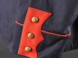 a close up of a blue jacket with red buttons on a mannequin