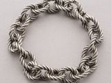 a close up of a rope bracelet on a white surface