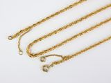 a close up of a gold chain on a white surface