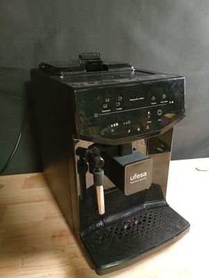 une machine à café noir posée sur une table en bois