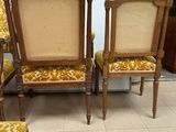 three chairs with yellow upholstered cushions are in a room with a white wall