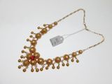 gros plan d'un collier sur une surface blanche avec une étiquette de prix
