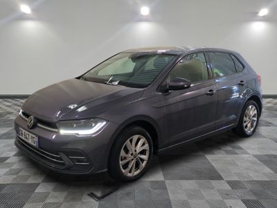 Une Volkswagen Golf grise est garée dans une pièce au sol carrelé en damier.