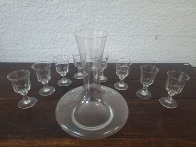 des bouteilles et des verres posés sur une table sur laquelle se trouve un vase