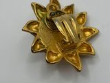 a close up of a gold pin with a flower on it