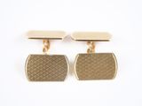 une paire de boutons de manchette en or sur fond blanc