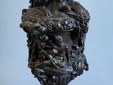 a statue of a man riding a horse on top of a vase