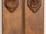 pair of carved wood plaques depicting a woman ' s head and a man ' s head