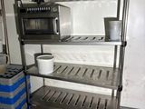 a metal shelf with a microwave on top of it