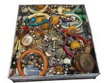 a metal box filled with lots of assorted jewelry