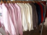 a lot of clothes hanging on a rack in a room