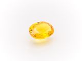 a yellow sapphire stone on a white background