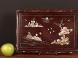 a wooden box with a painting on it next to an apple