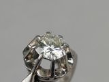 a close up of a diamond ring on a white surface