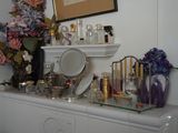 une commode avec un miroir et de nombreux flacons de parfum posés dessus