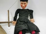 a doll that is sitting on the ground next to a toy boat
