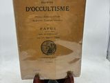 un vieux livre posé sur un support en bois, sur une surface blanche