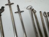 a lot of old swords that are on a table
