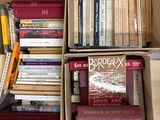 de nombreux livres qui se trouvent dans une boîte posée par terre