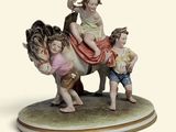 une figurine représentant une femme et deux enfants à cheval