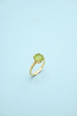 a close up of a ring with a green stone on it