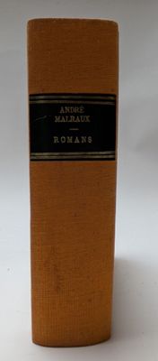 un vieux livre posé sur une table à côté d'un fond blanc
