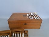 a wooden box with silverware in it on a table
