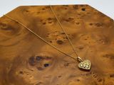 une image représentant une boîte en bois sur laquelle est posé un collier en or
